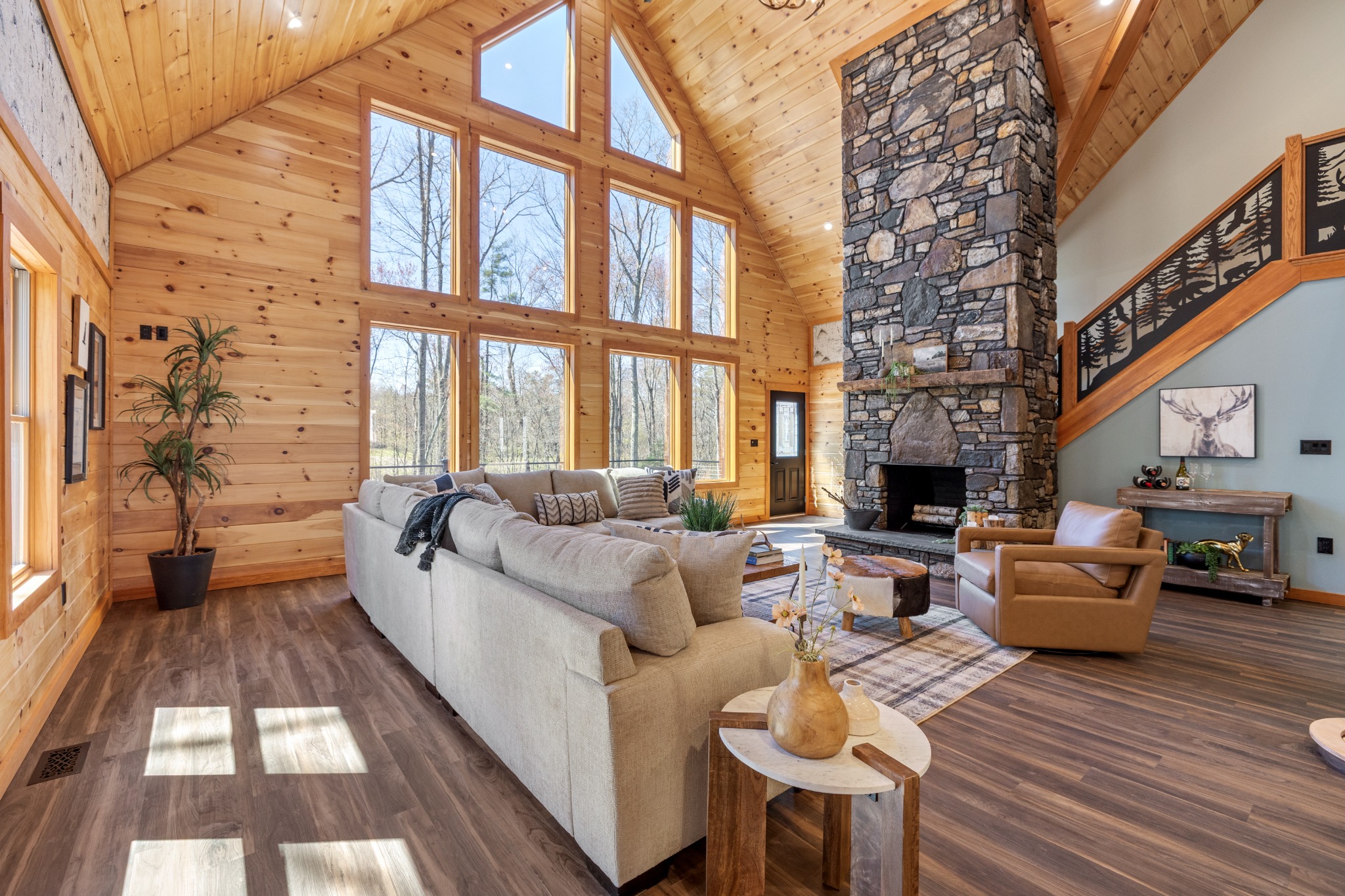 Real estate photography of a great room with a stone fireplace and tall windows